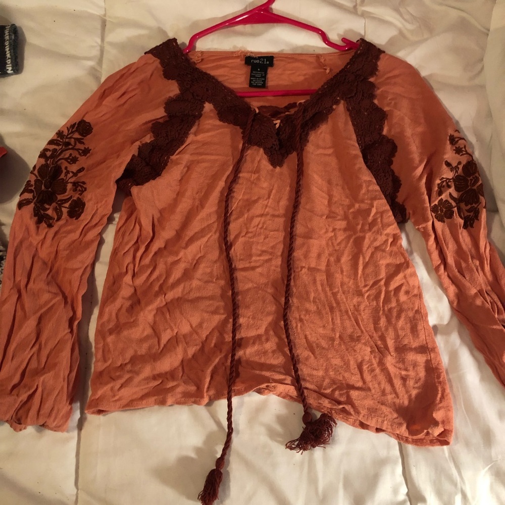 orange top with flowers on side